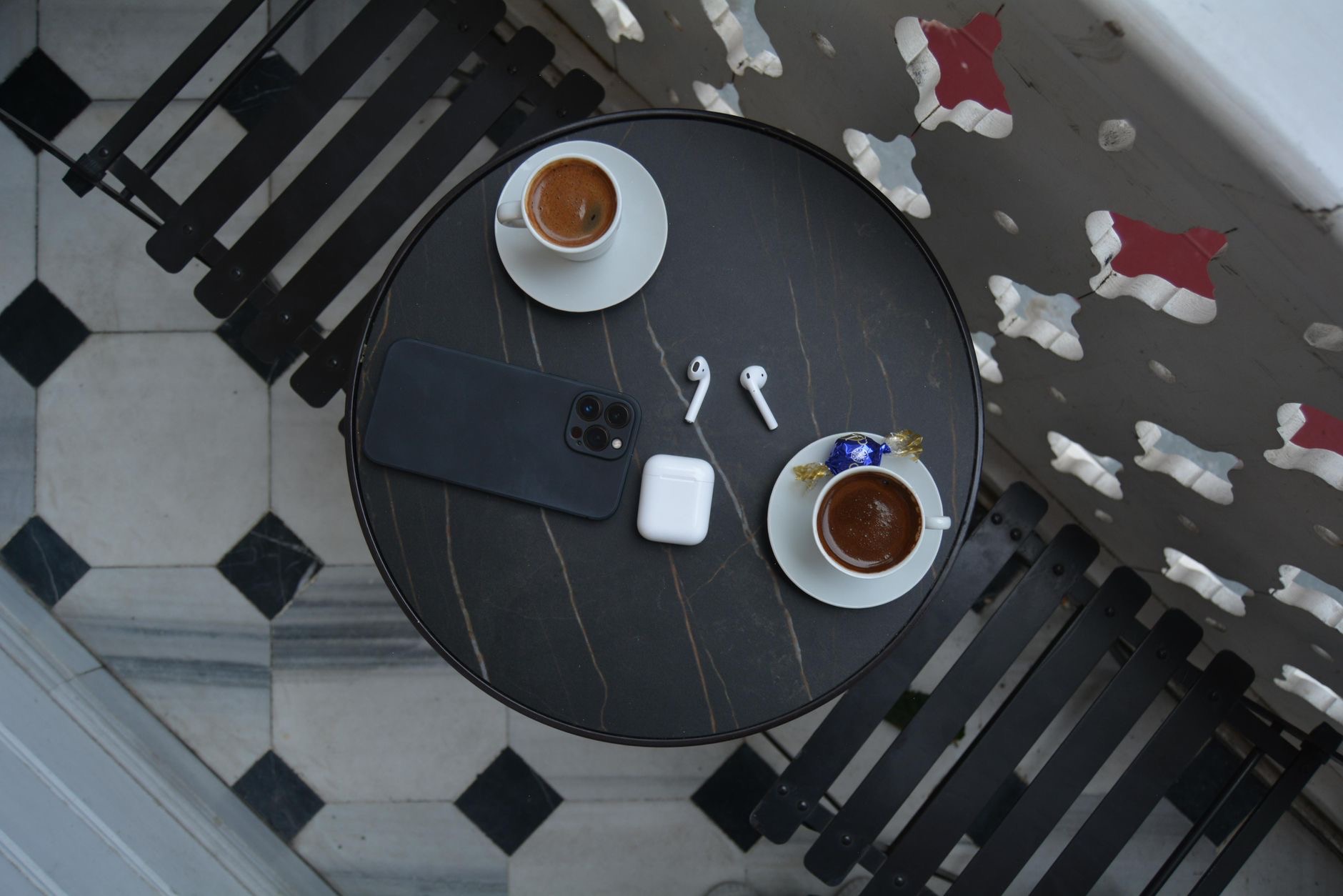 AirPods resting next to an iPhone on a table