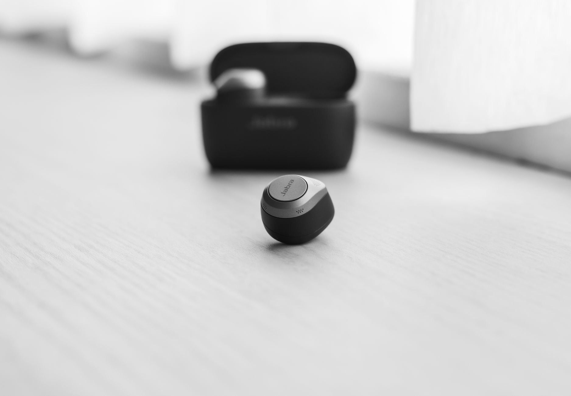 A single wireless earbud held in fingers