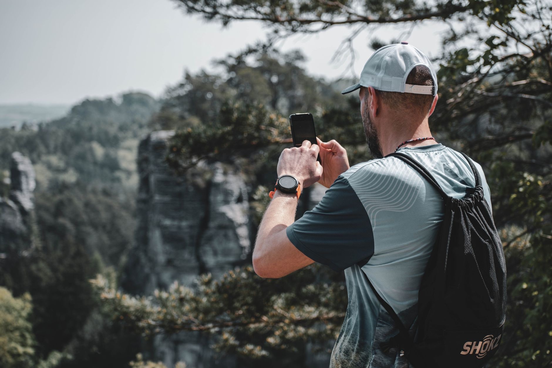 A person hiking while checking a smartwatch