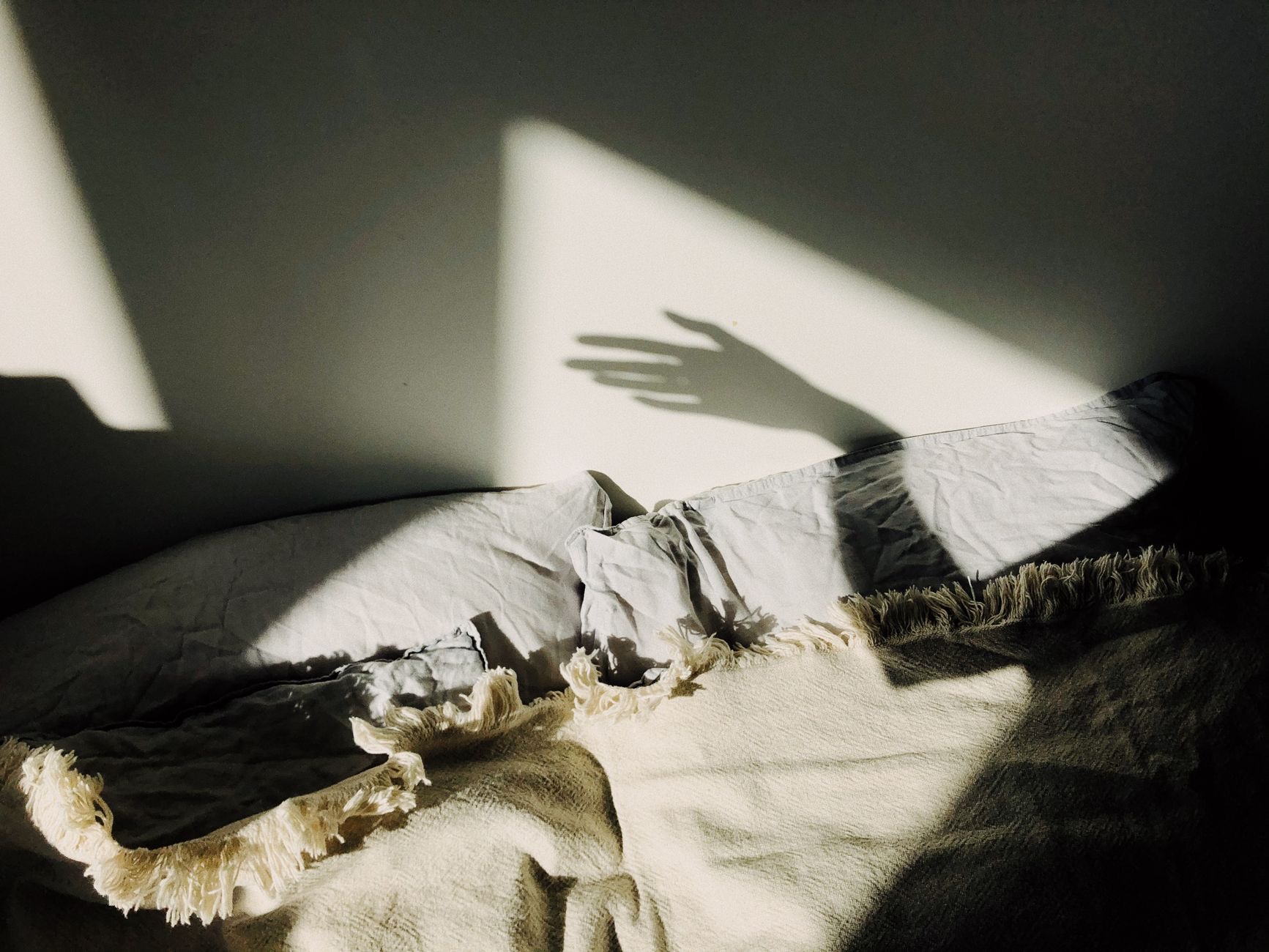 Person relaxing in bed with soft lighting