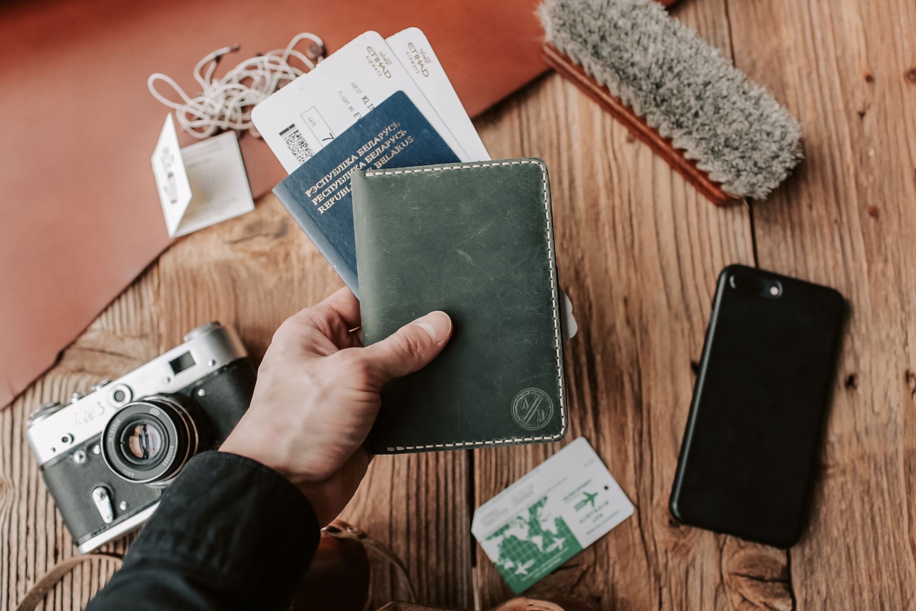 Wireless earbuds beside a passport and boarding pass