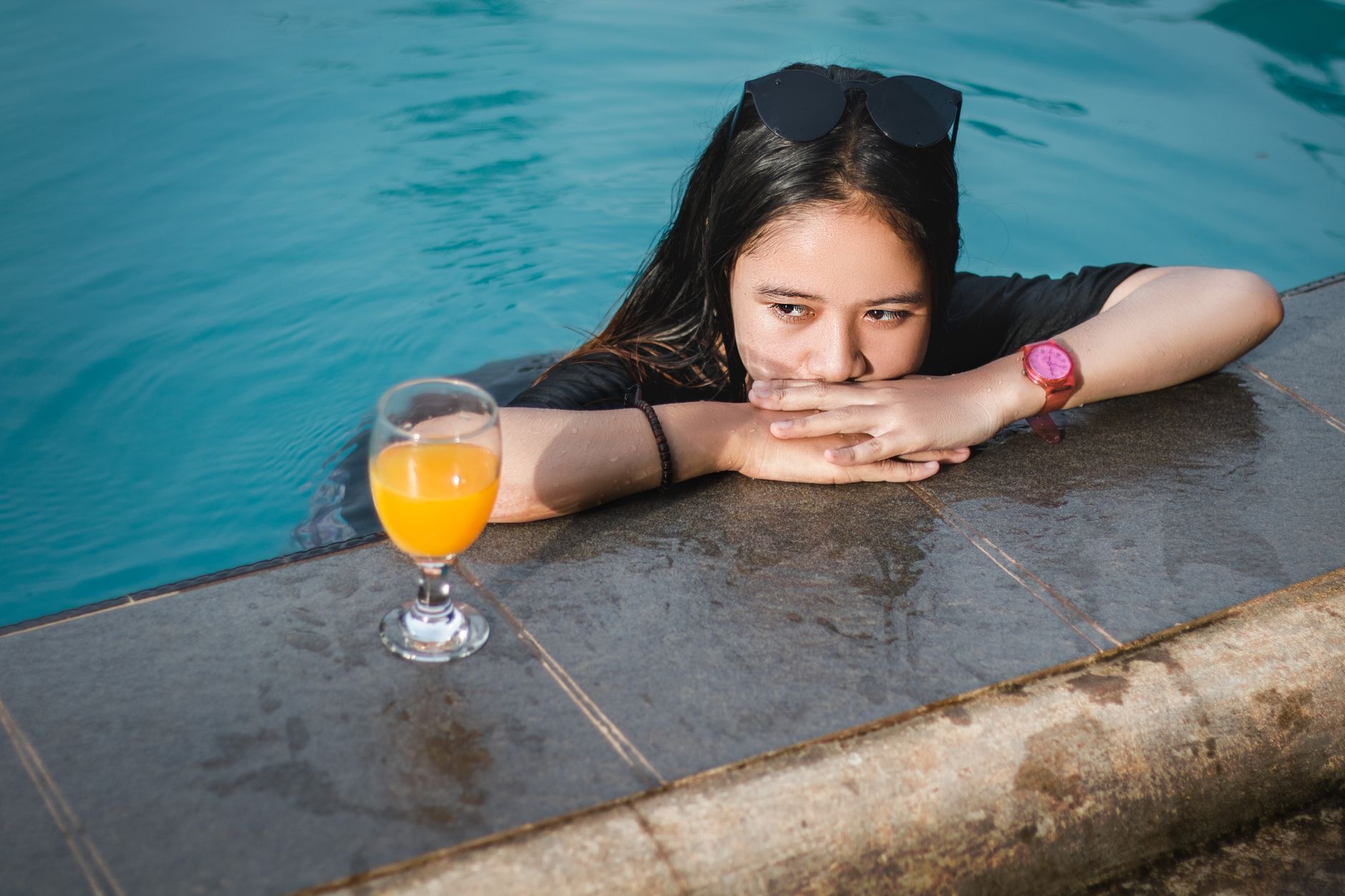 Person by the poolside checking a watch