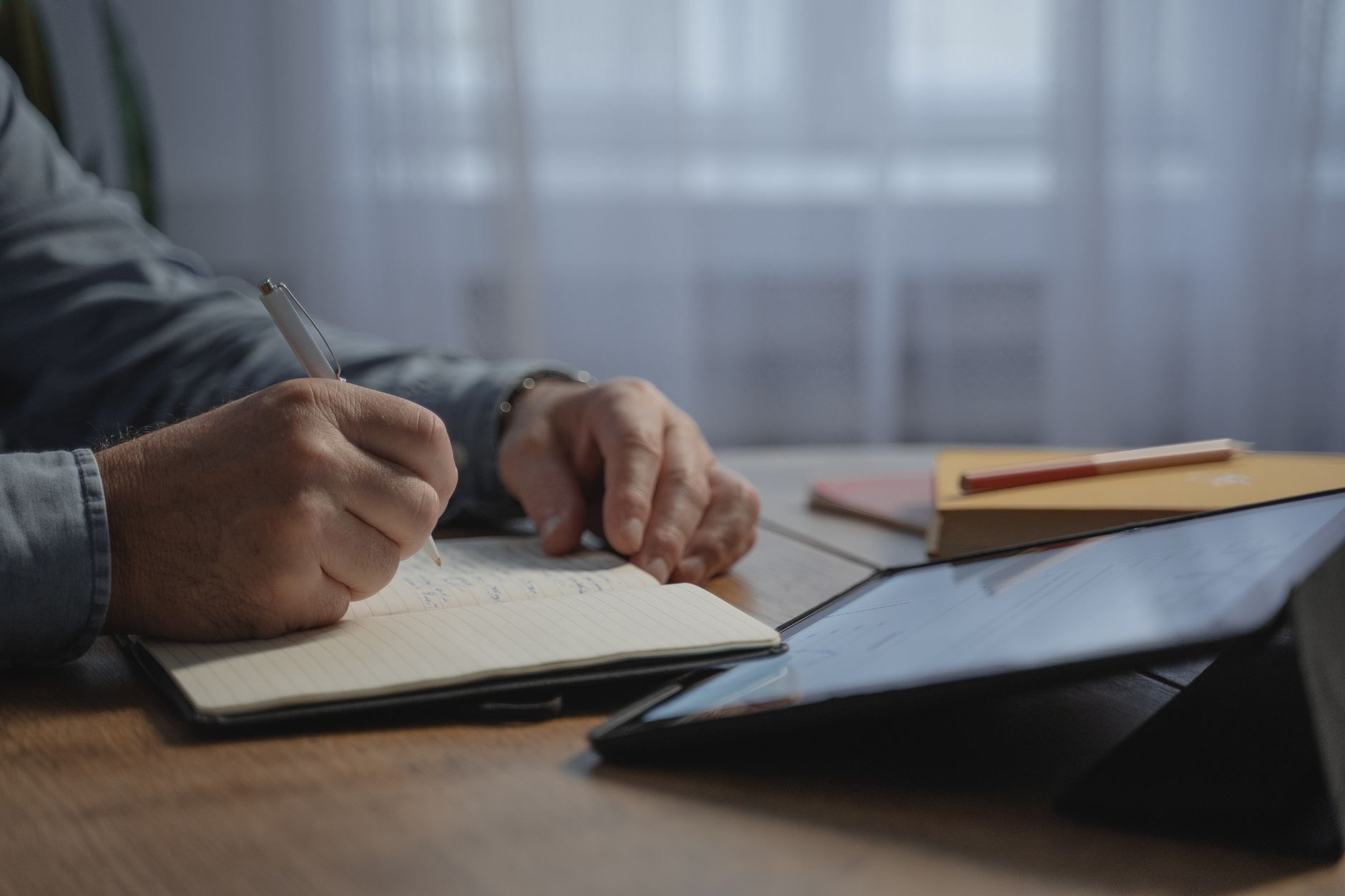 A person taking handwritten notes on a tablet