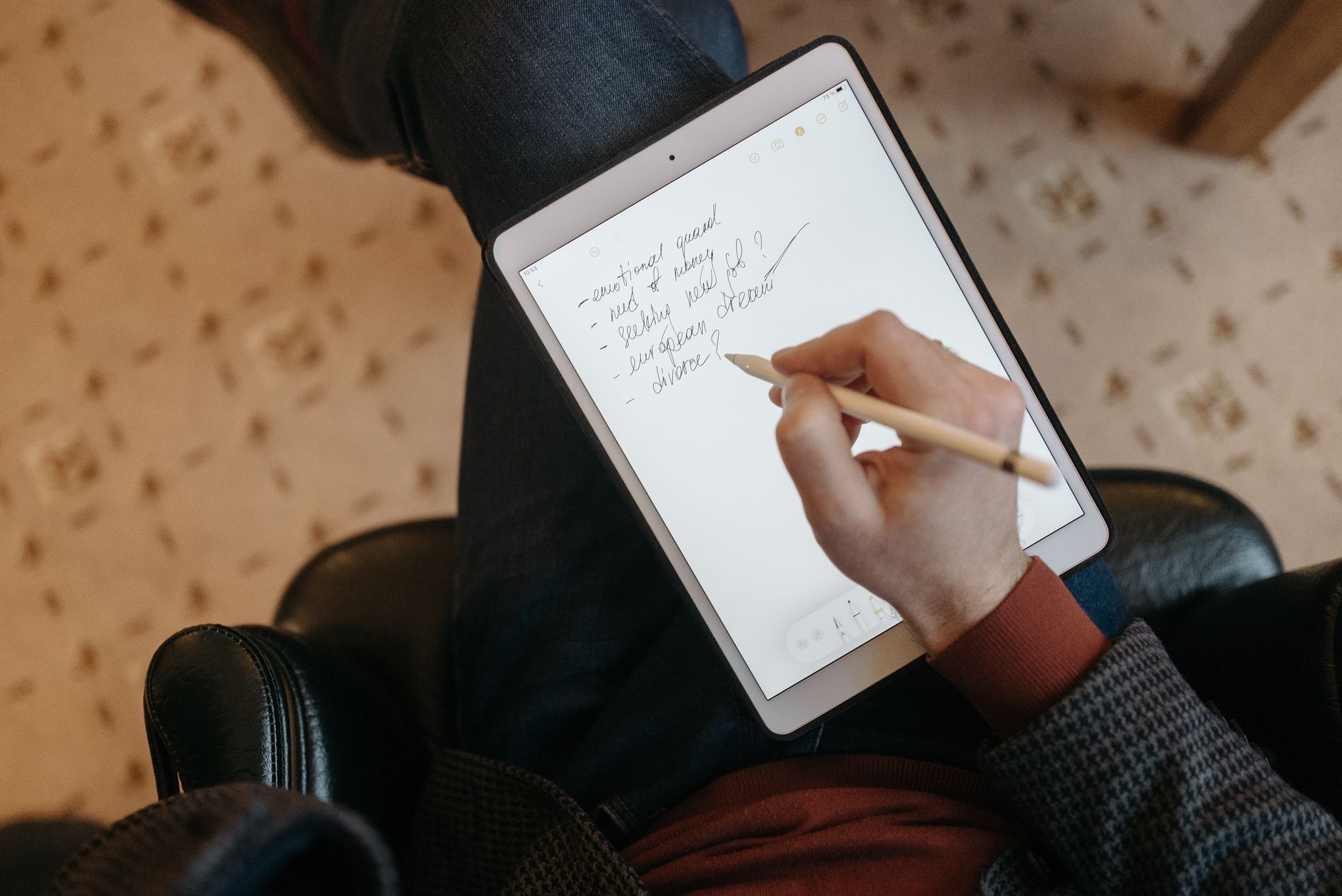 Person writing notes on an iPad with a stylus
