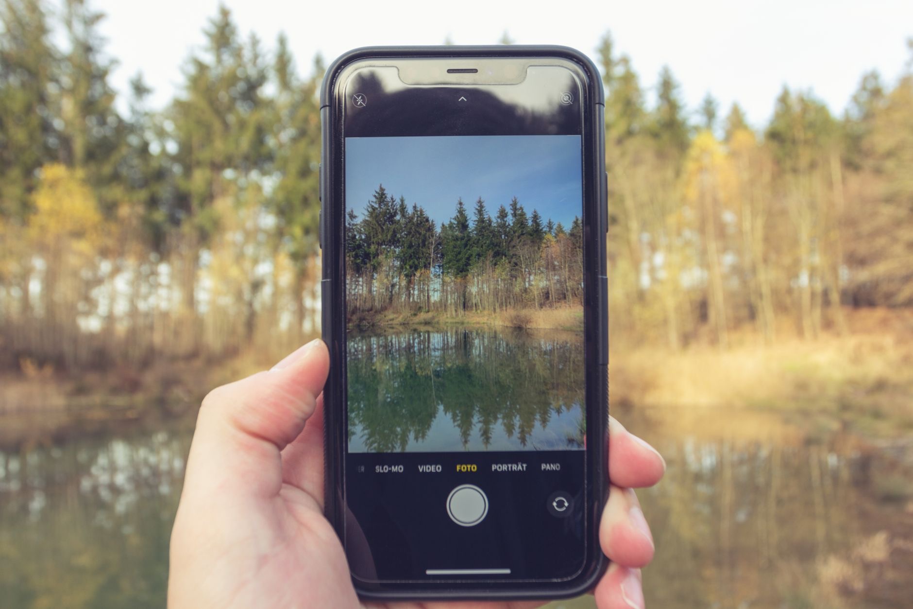Person framing a landscape photo on a phone