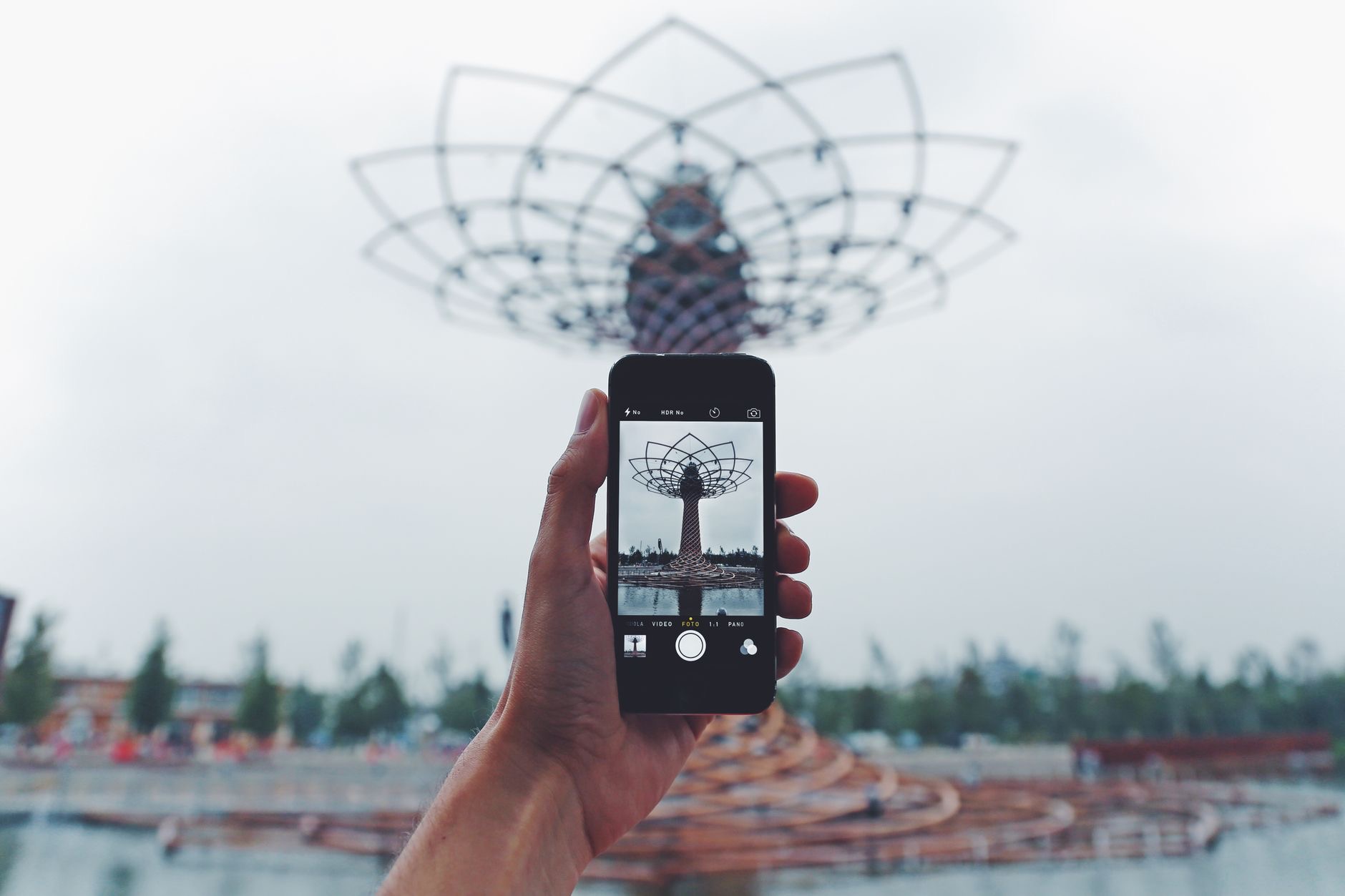 Hand holding a phone photographing a landmark