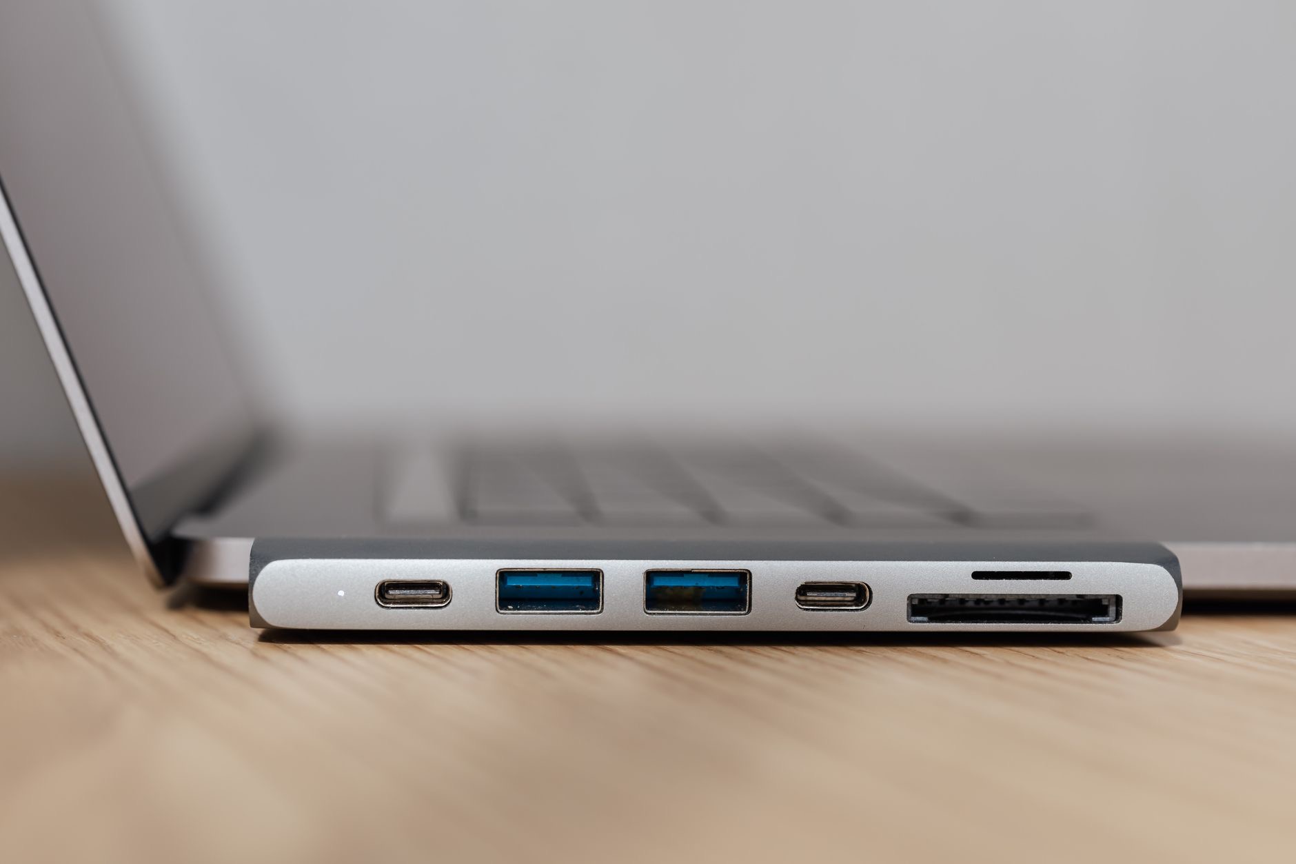 USB-C hub with multiple ports connected to a silver laptop