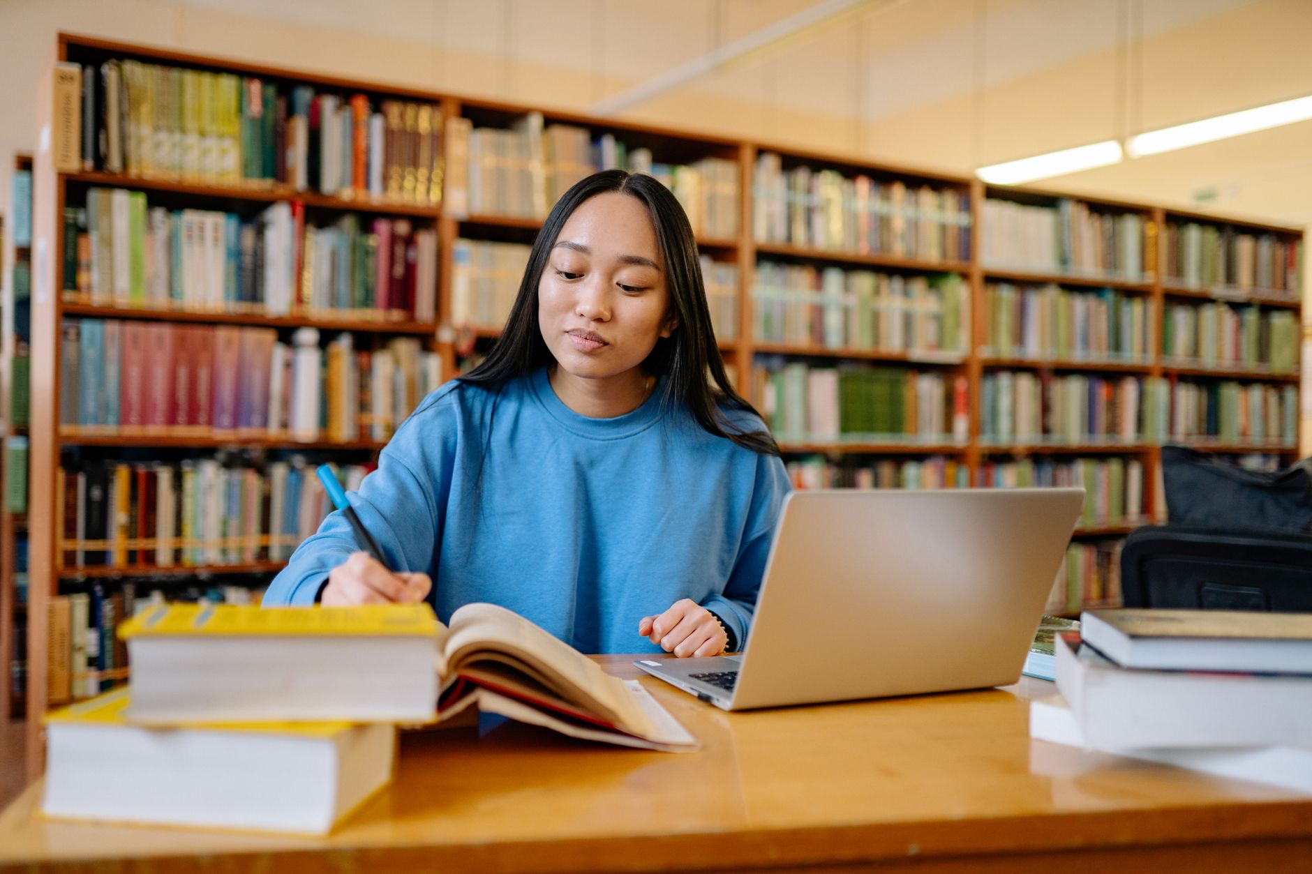 A student studying with a laptop and books