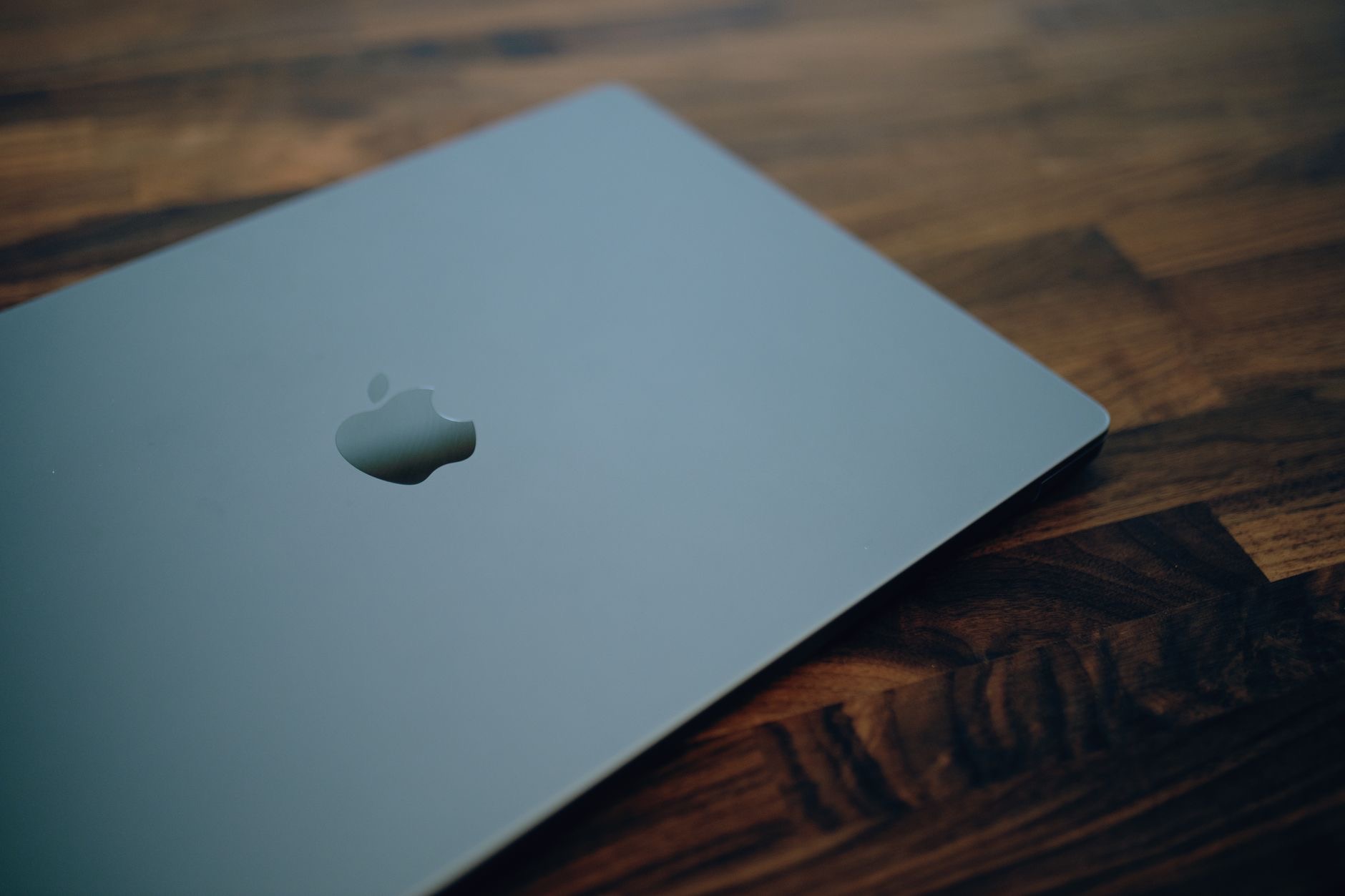 A MacBook open on a wooden desk