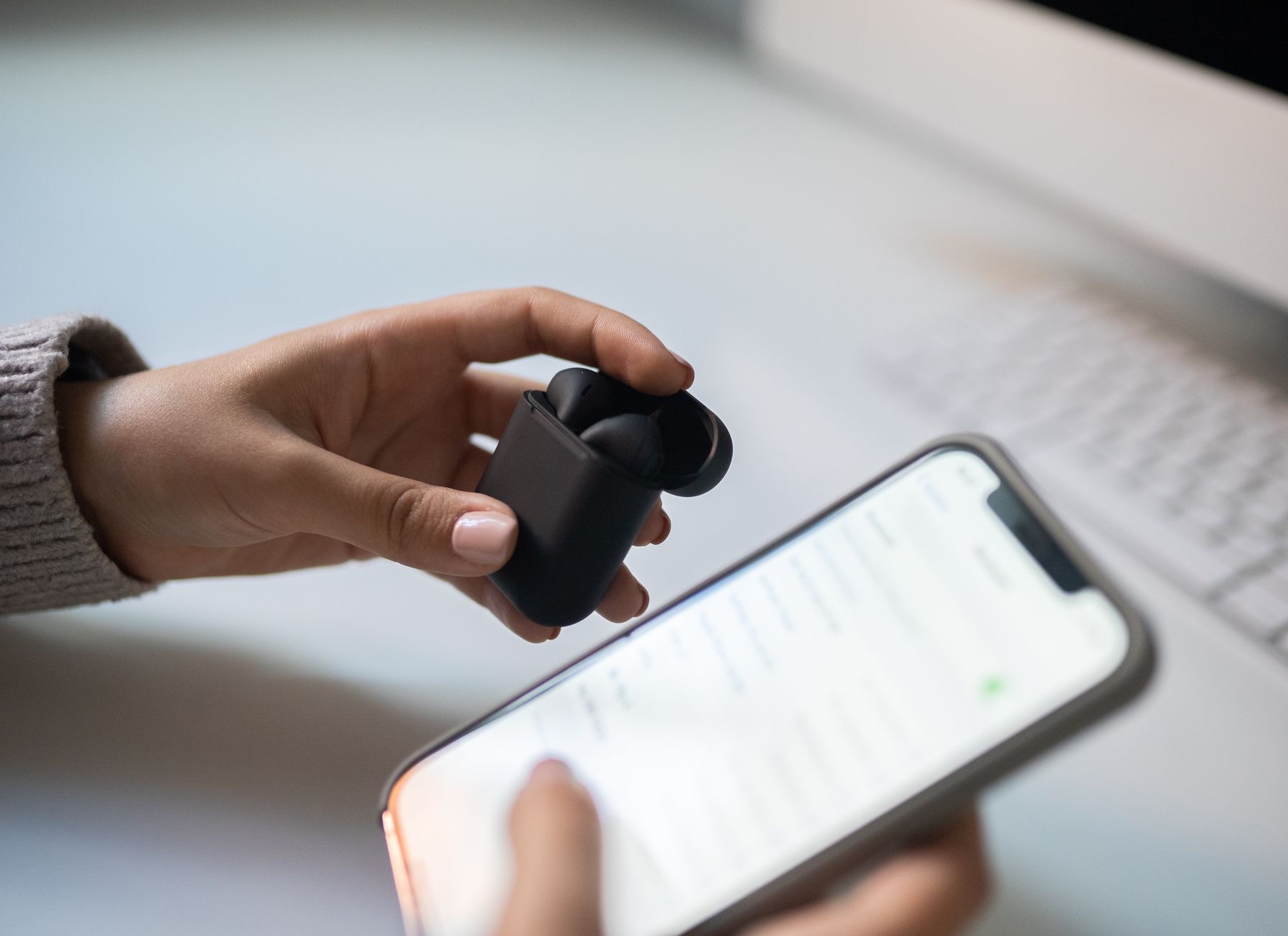 An open AirPods case near a phone
