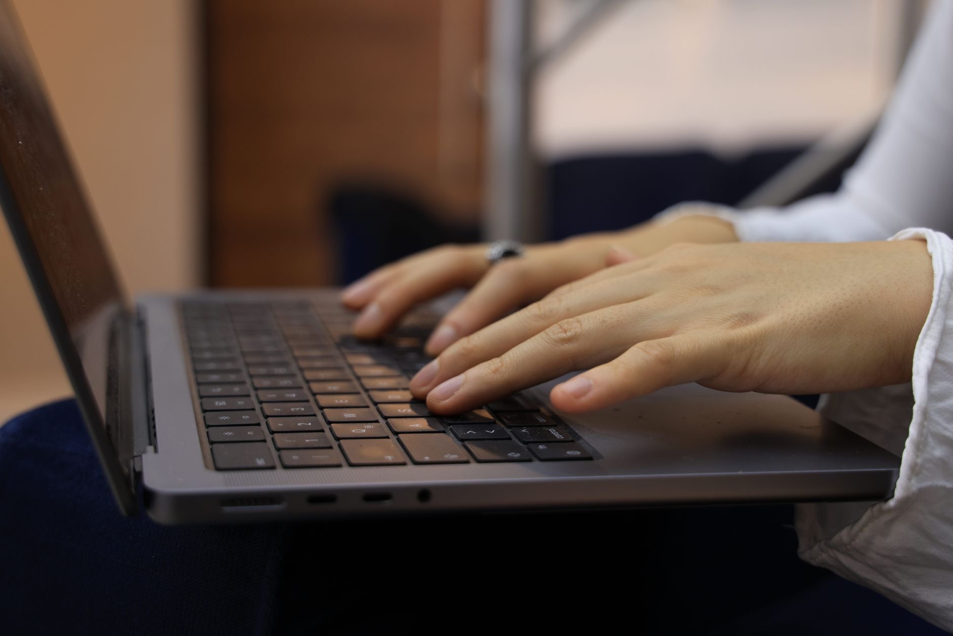 A person typing on a laptop keyboard