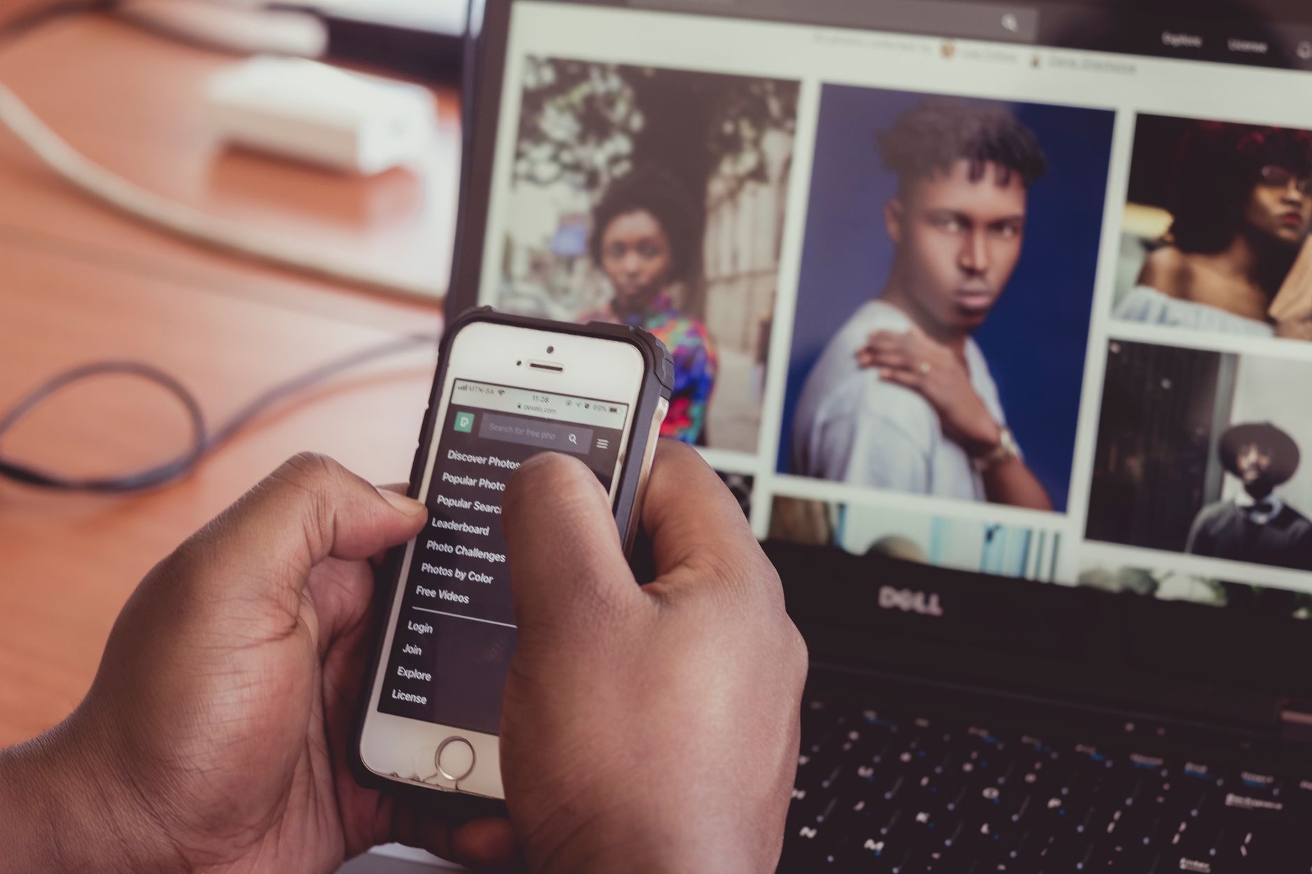 Person holding an iPhone showing the photo library on screen