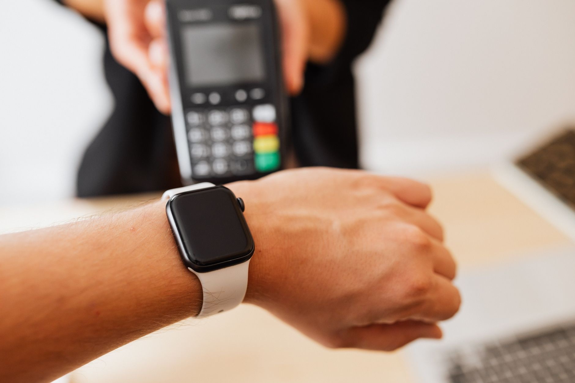 Customer paying with a smartwatch at a cafe counter