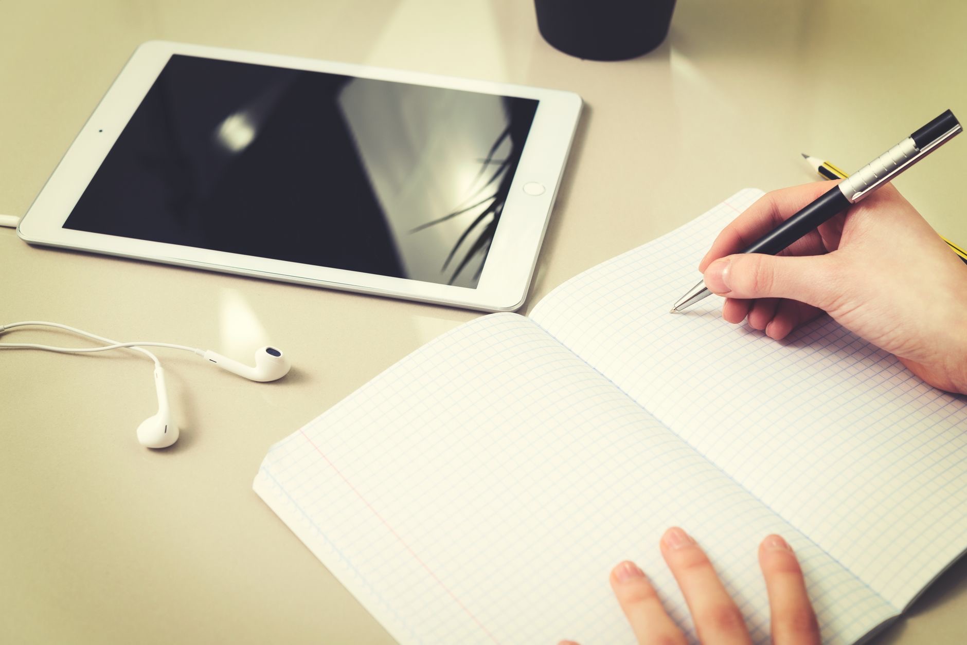 A student taking notes on a tablet for college