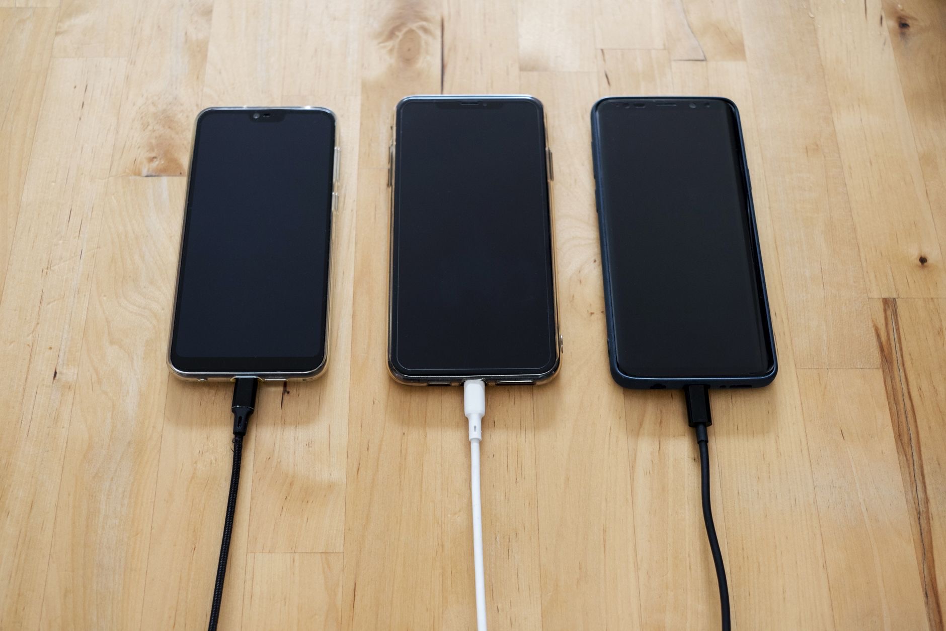 A smartphone connected to a charging cable
