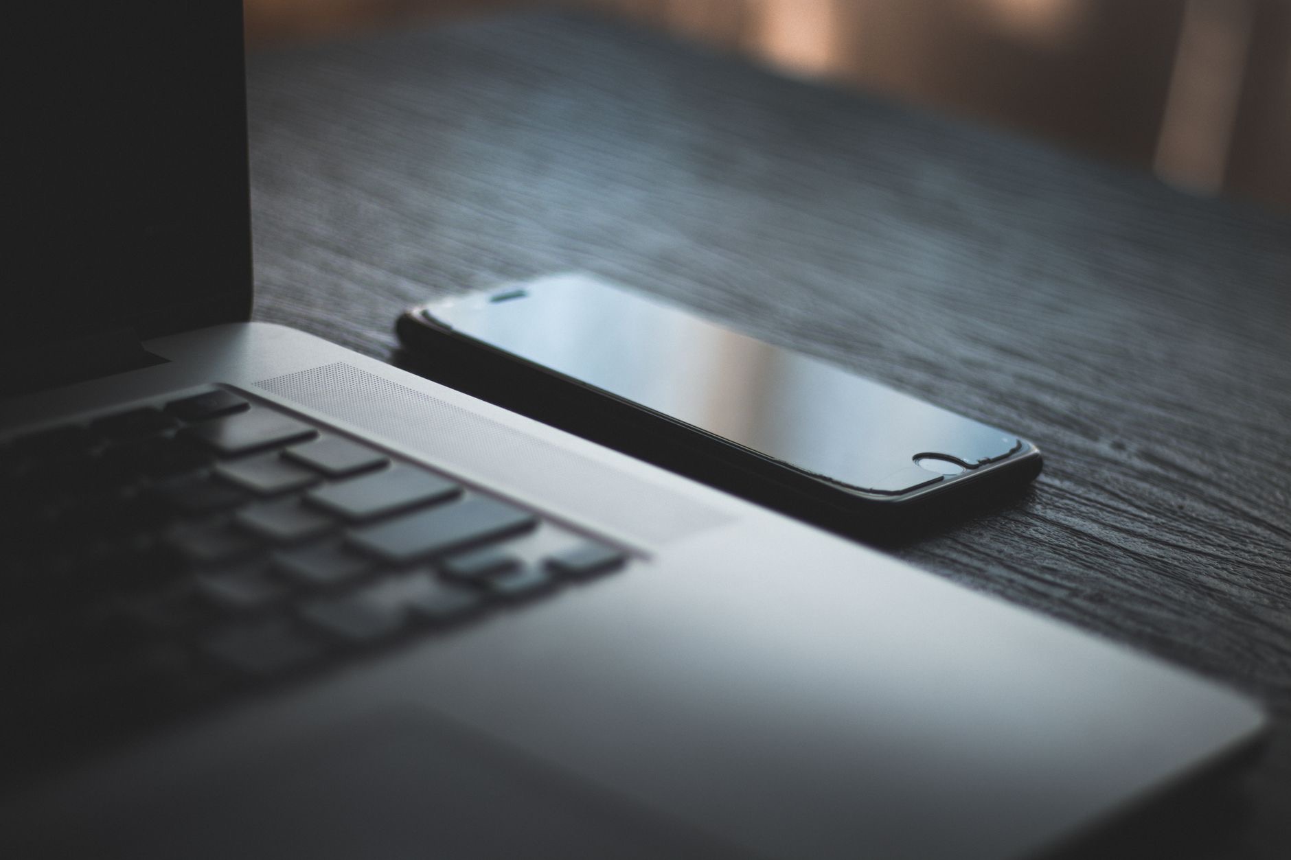 A smartphone next to a laptop