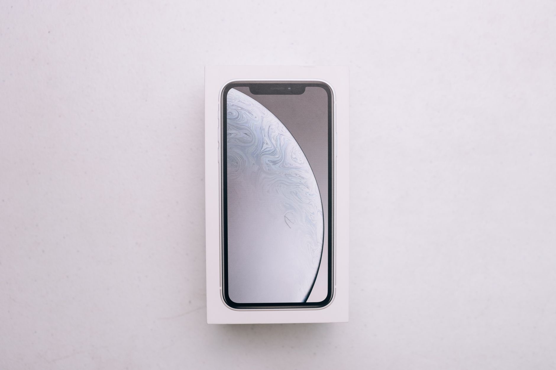 A smartphone next to its packaging