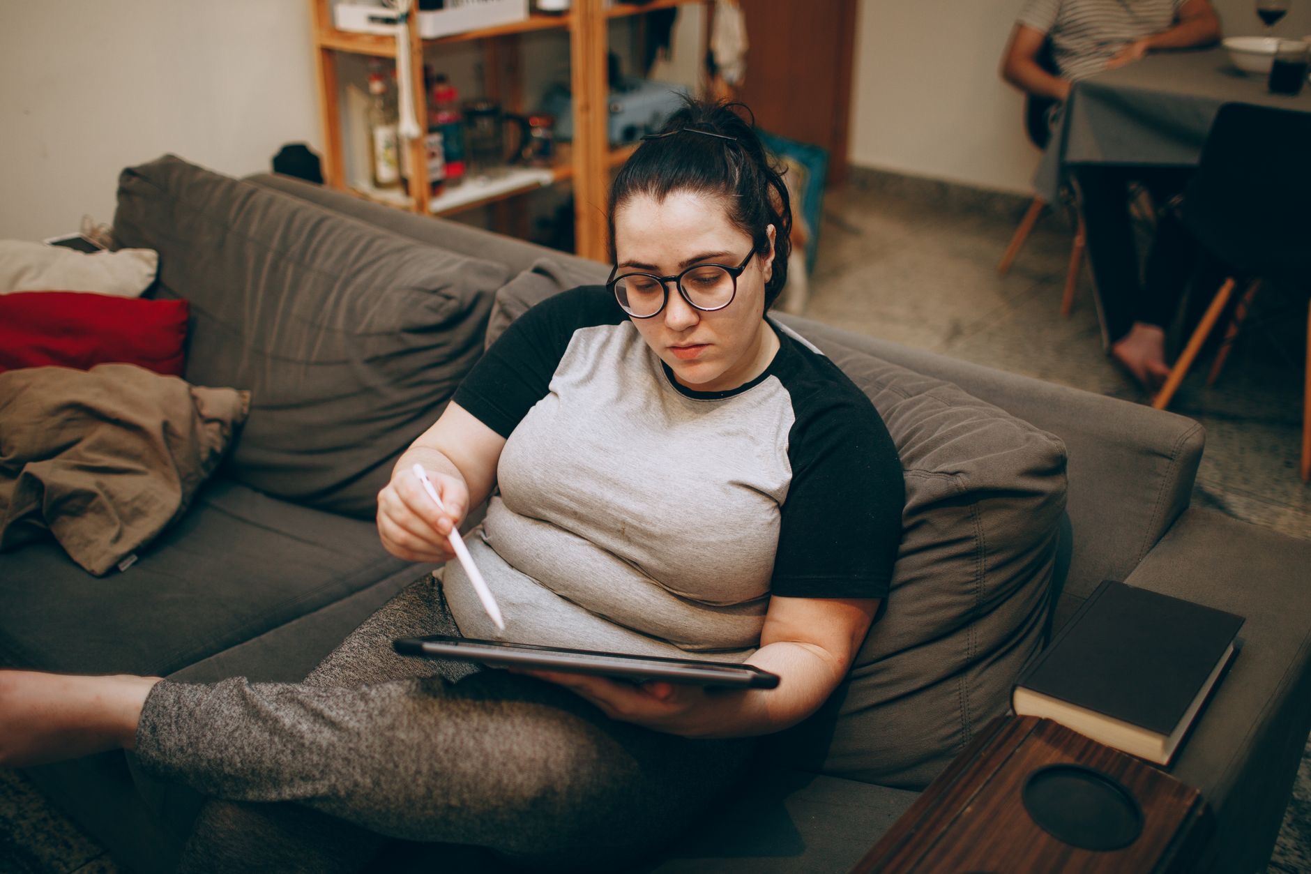 A person relaxing with a tablet on a couch