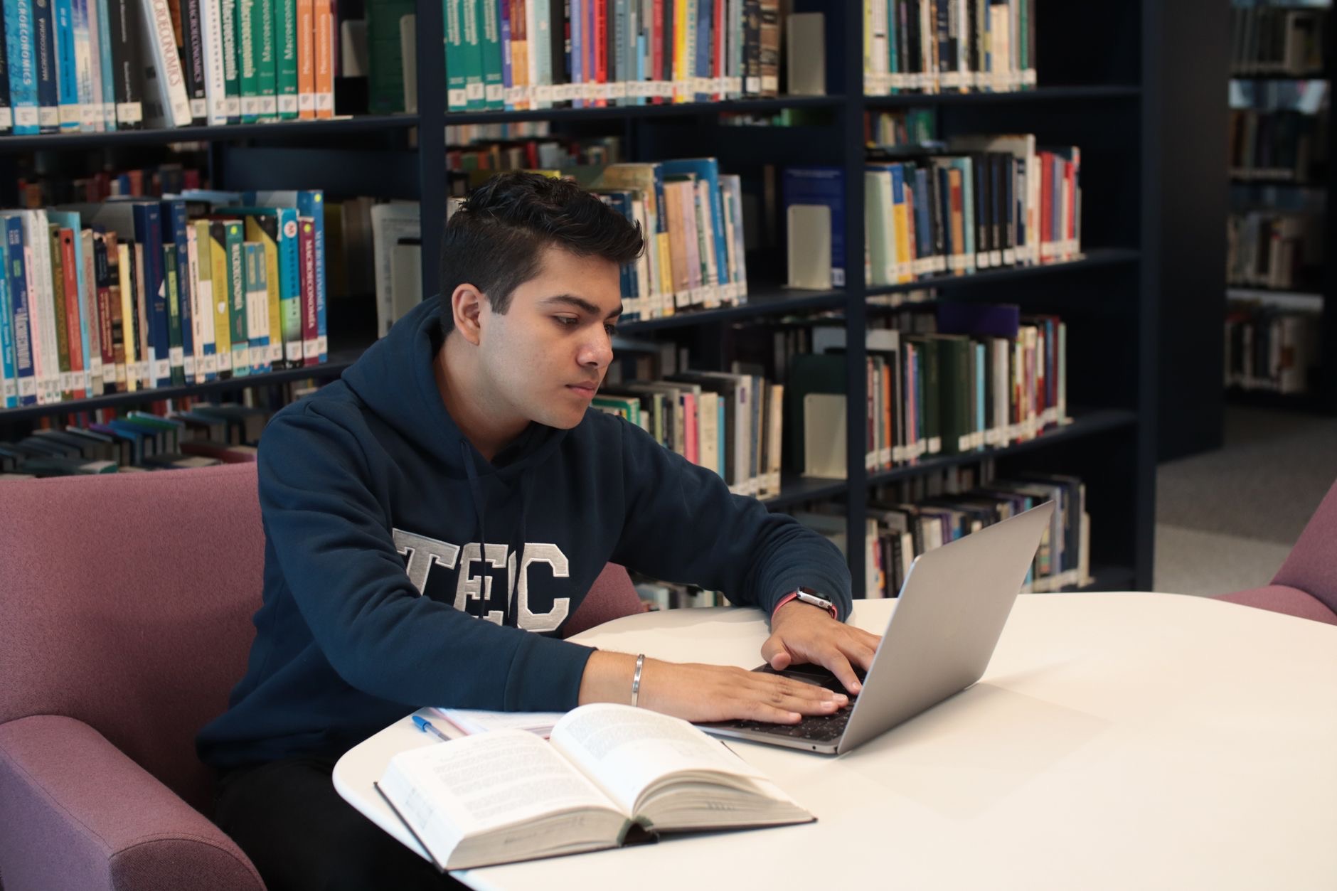 A student studying with a MacBook Air laptop