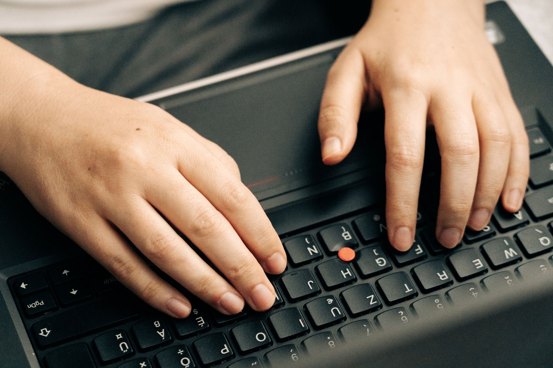 Person typing on a MacBook with both hands