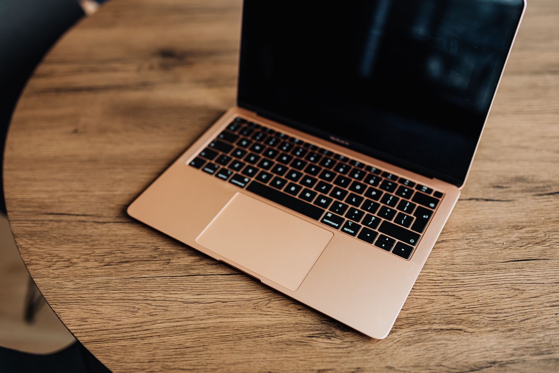 A laptop open on a wooden table