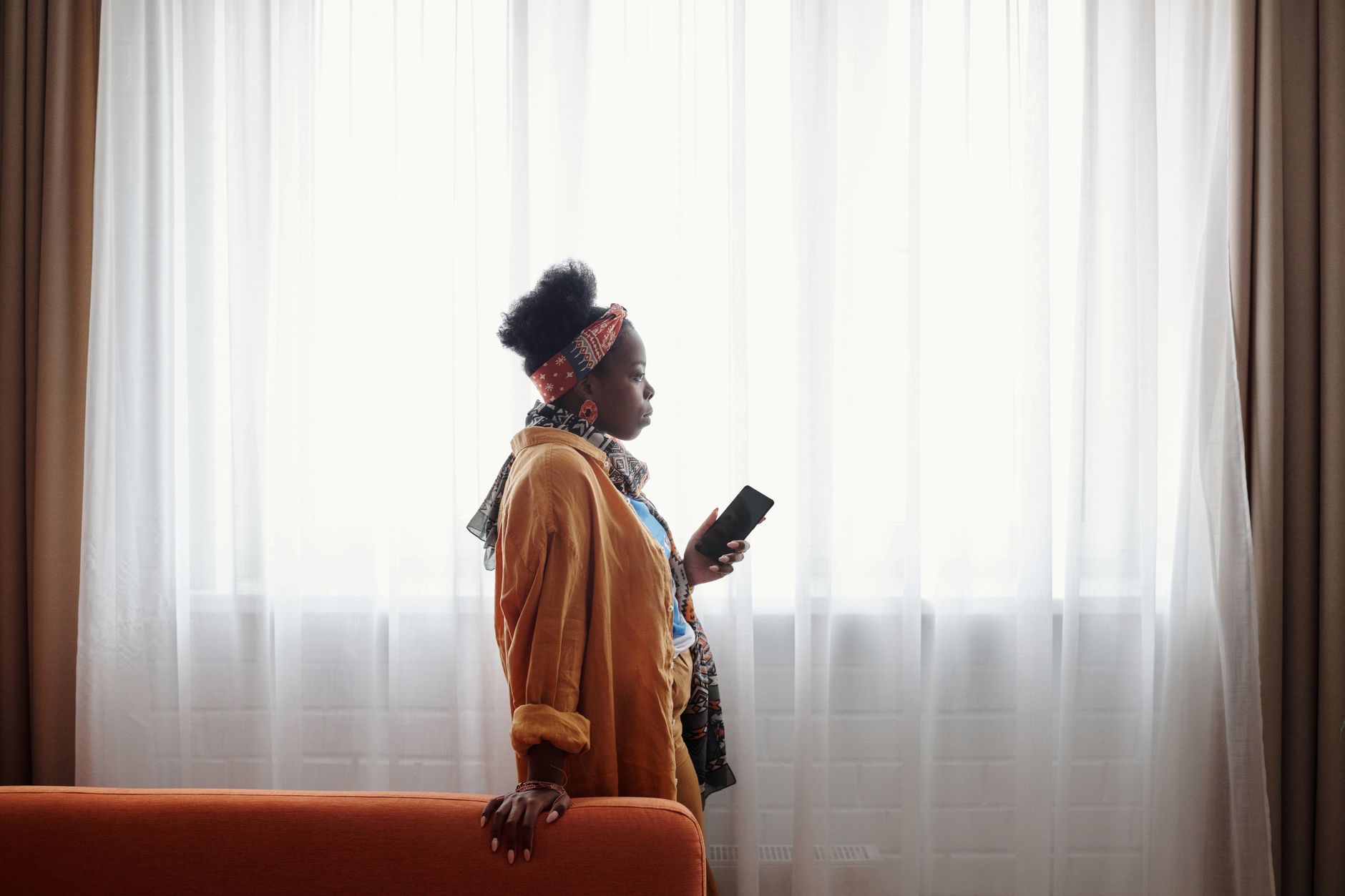 Person considering a phone purchase in a thoughtful pose