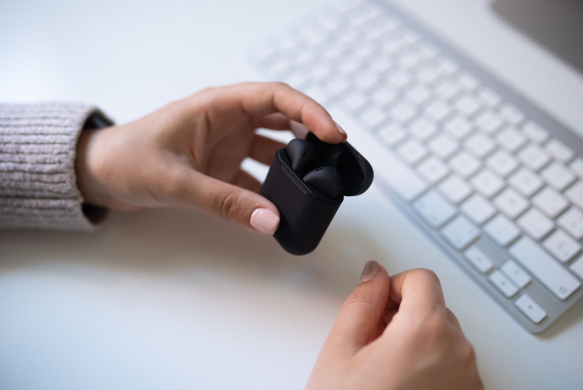 Wireless earbuds held in a hand
