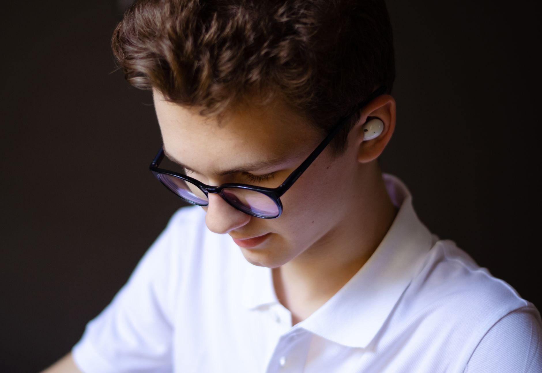 A teen using earbuds
