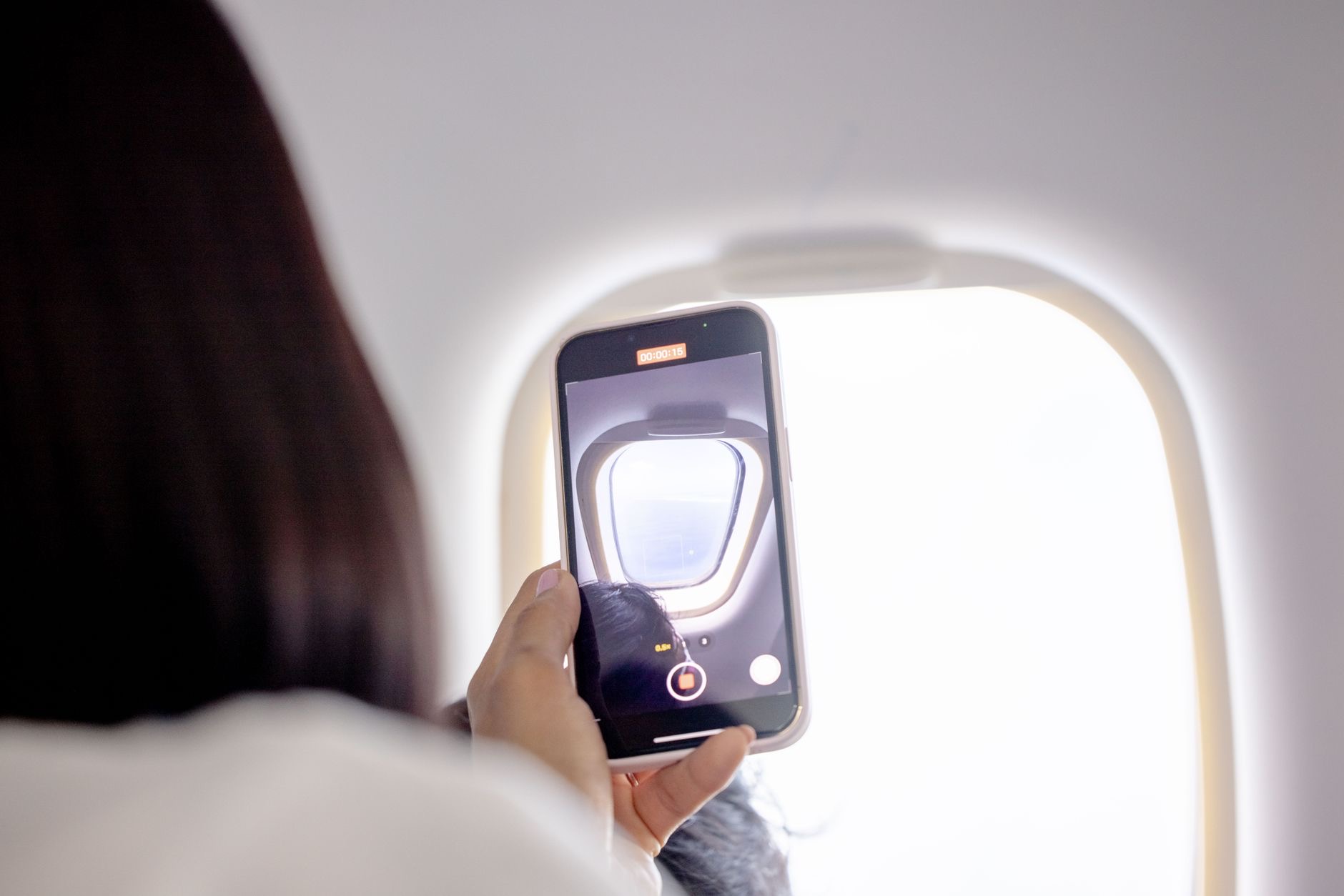 A traveler using a phone on a plane