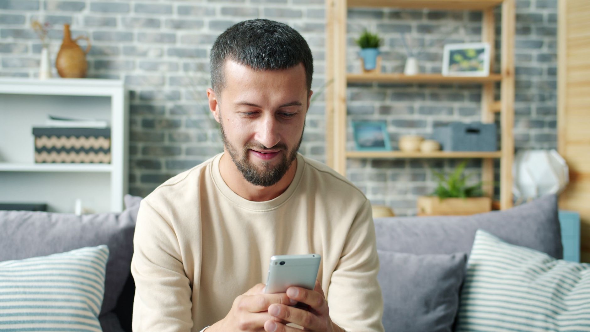 Someone smiling while using their phone