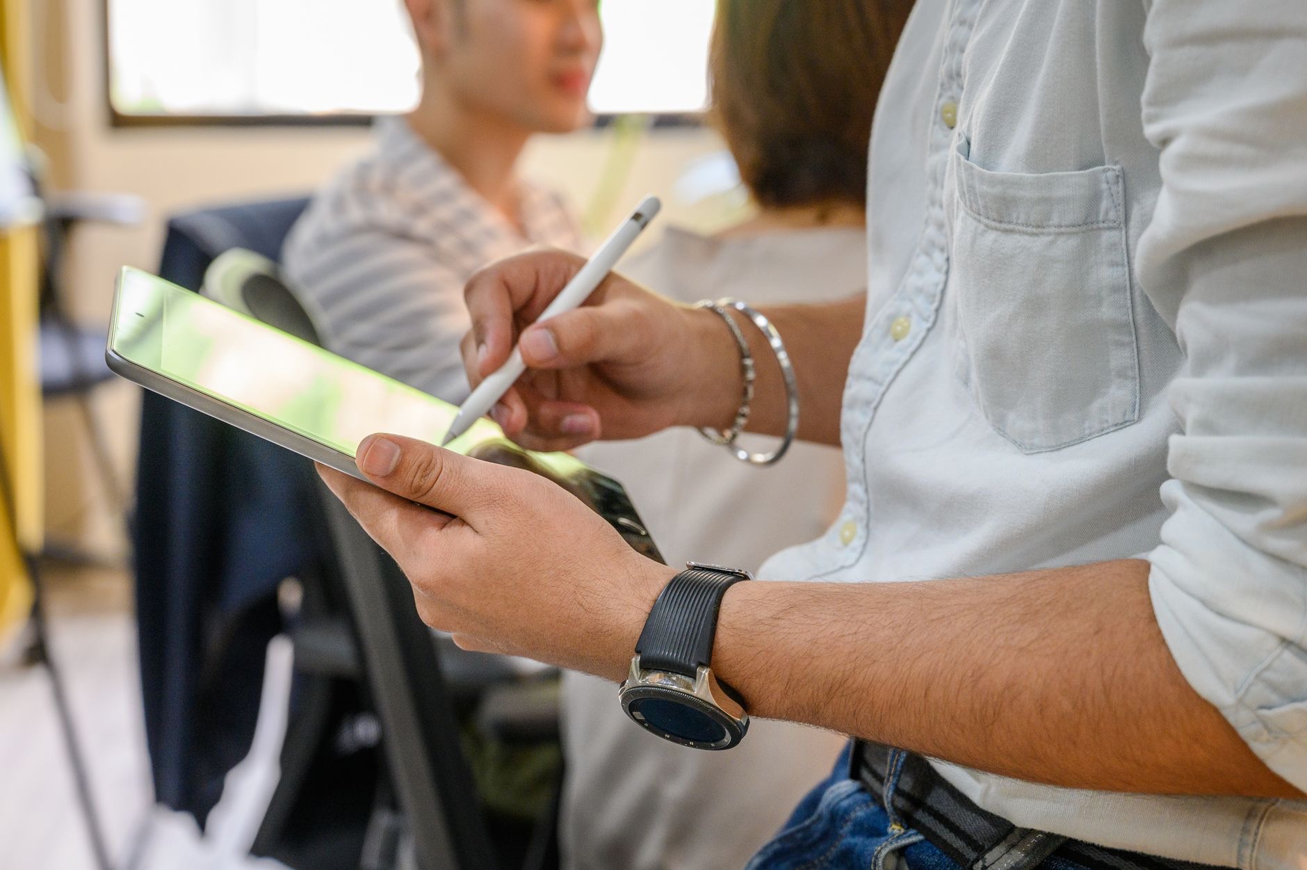 Person taking notes on an iPad with a pencil