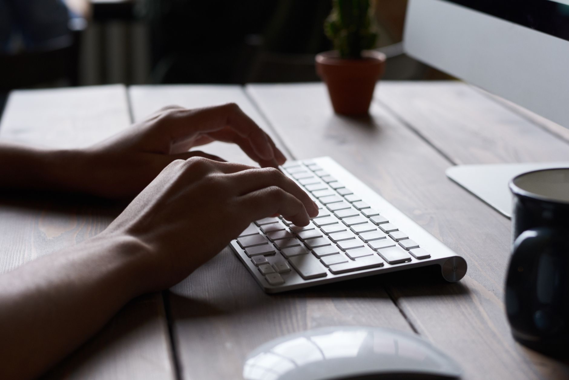 Person typing on a Mac keyboard